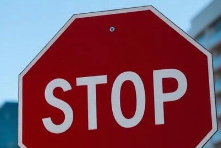 A stop sign with the bottom segment sliced off. 