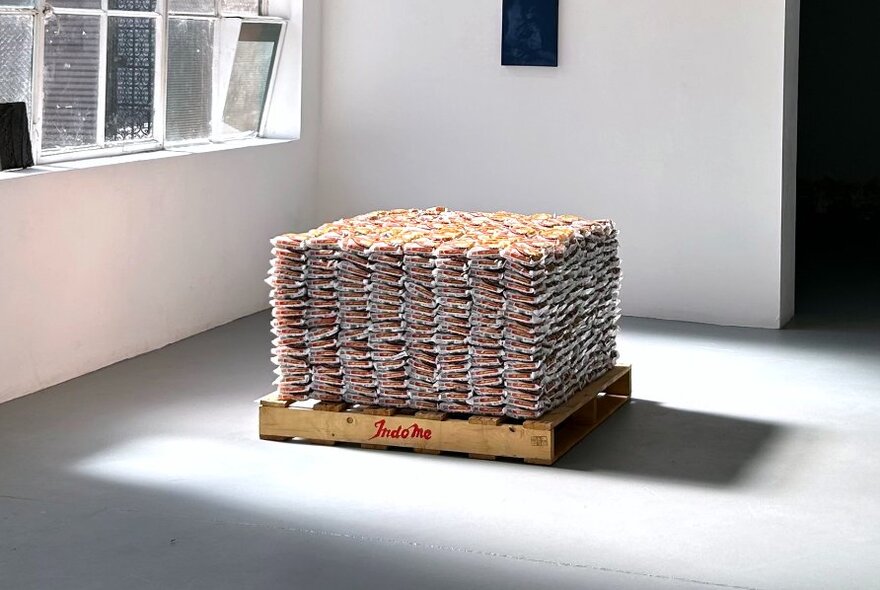 Sculptural art installation on a pallet in a white gallery space.