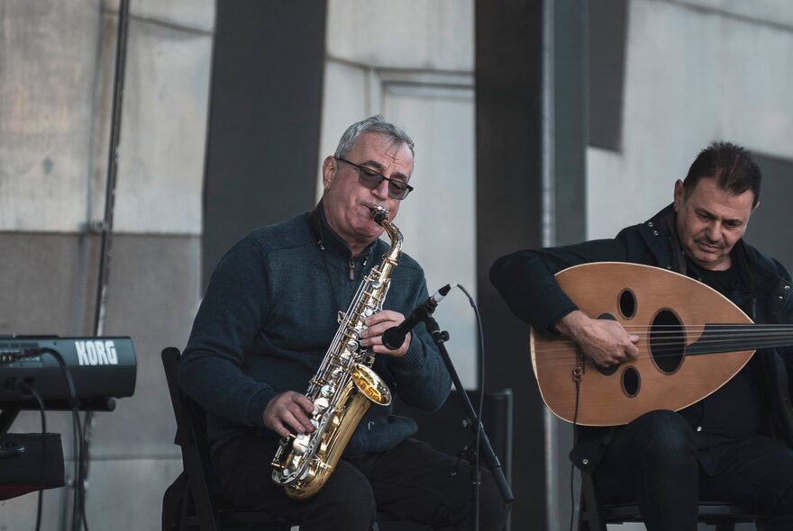 Musicians playing saxophone and mandolin.