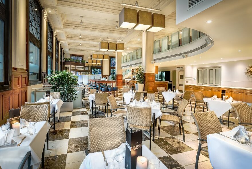 Large, well-lit restaurant with white tablecloths on the tables.