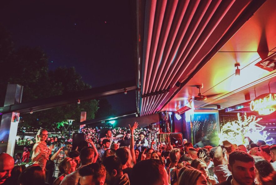 People crowding at an outdoor venue at night. 