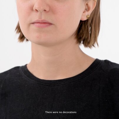 Medium close-up shows a woman with short brown hair and light skin wearing a black top, her eyes are not in the frame.