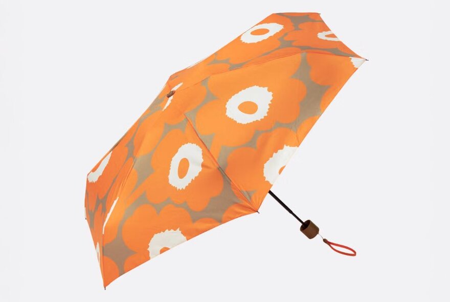 An umbrella with orange and white poppy flower print.