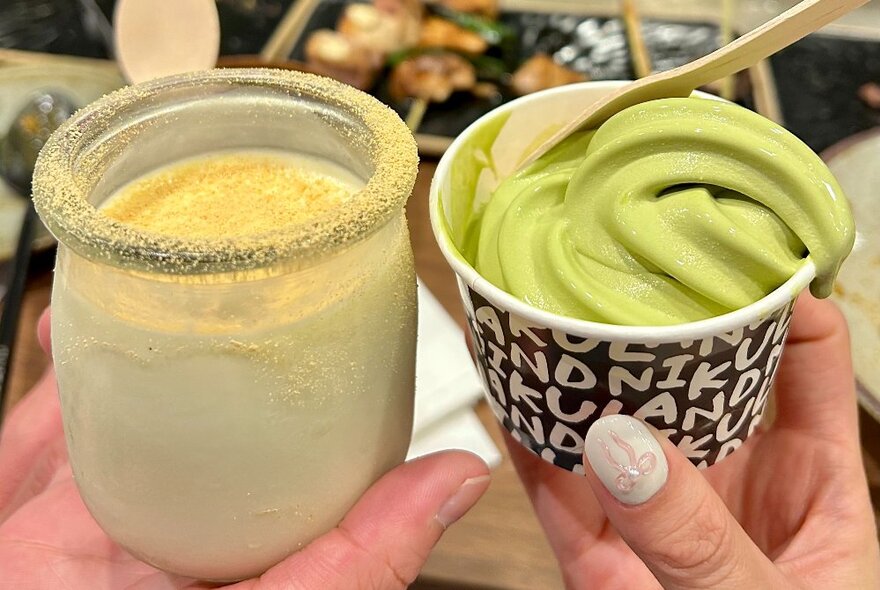 Hands holding a white drink in a jar and takeaway cup of matcha ice cream.