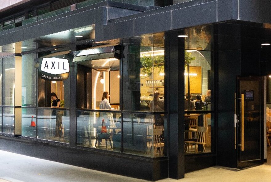Exterior of Axil Coffee on Bourke Street, with shop signage and people just visible inside.