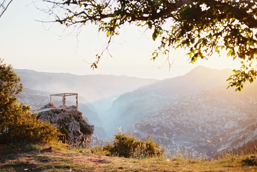 A remote clifftop in cloud with trees.