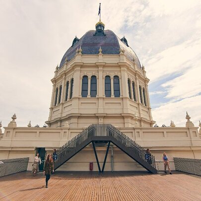 People walking around the outdoor balcony area in front of the Royal Exhibition Dome.