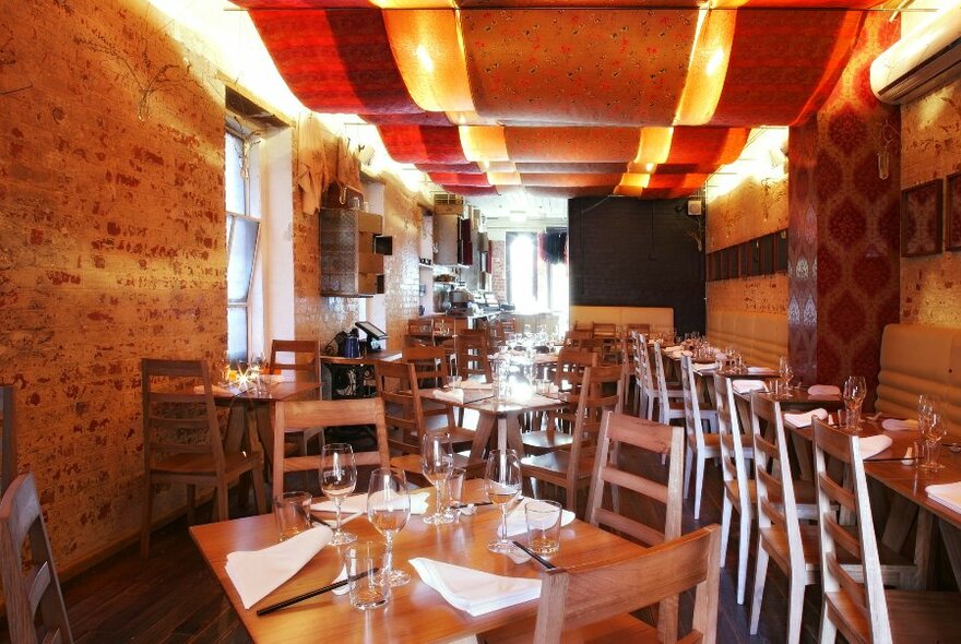 Interior of Seamstress bar with tables and rows of stools.