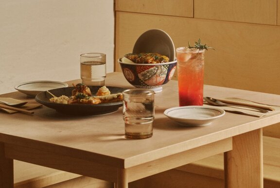 Japanese dishes of food and drinks on a low wooden table.