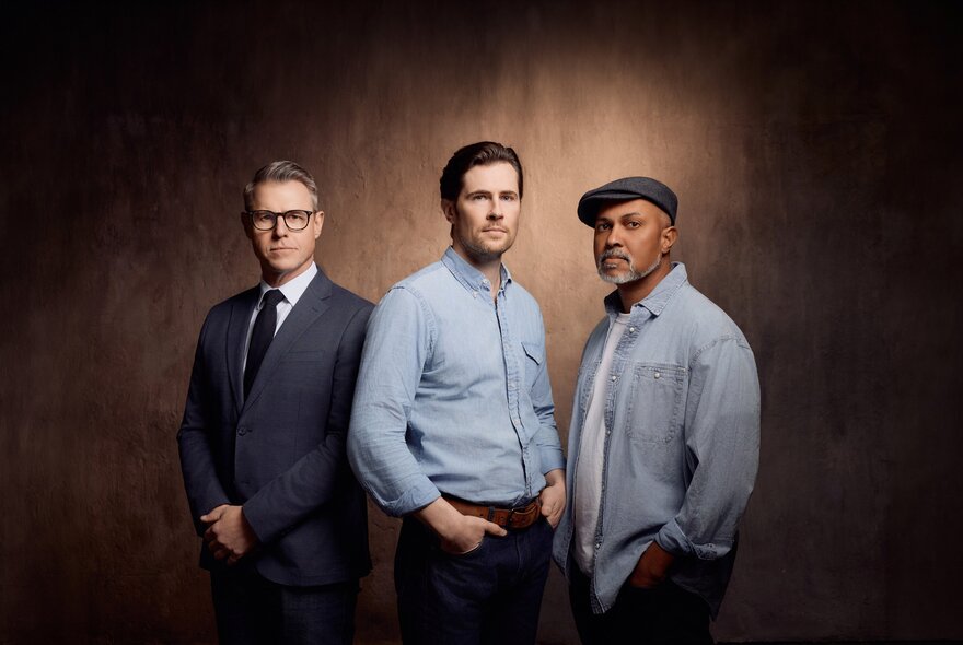 Three male actors - Rodger Corser, David Berry and Bert LaBonté - the lead cast for the stage adaptation of The Shawshank Redemption, posed against a light tan backdrop.