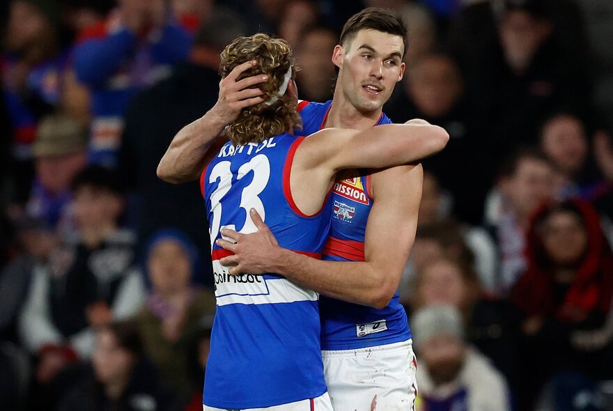 Western Bulldog AFL football players embracing during a match.