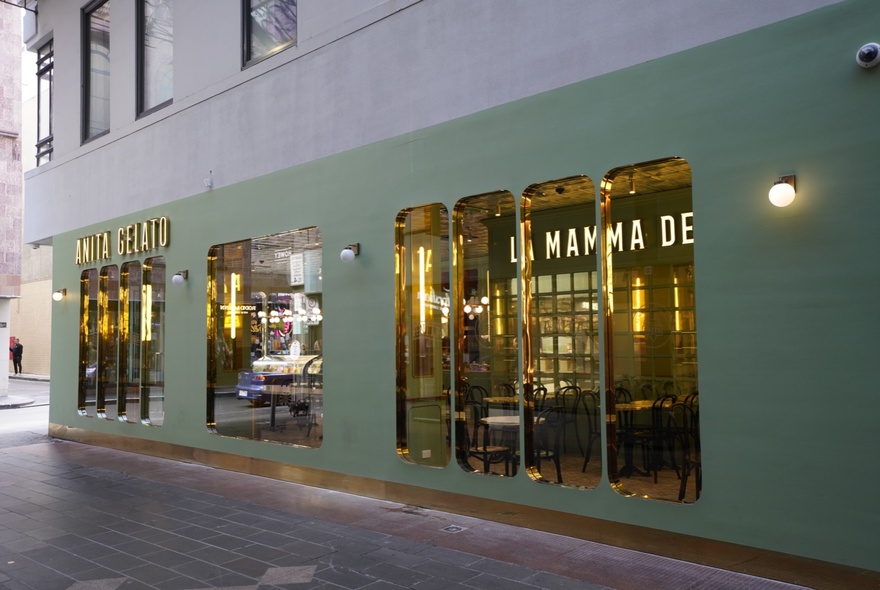 The green building exterior of Anita Gelato on the corner of a lane and a street.