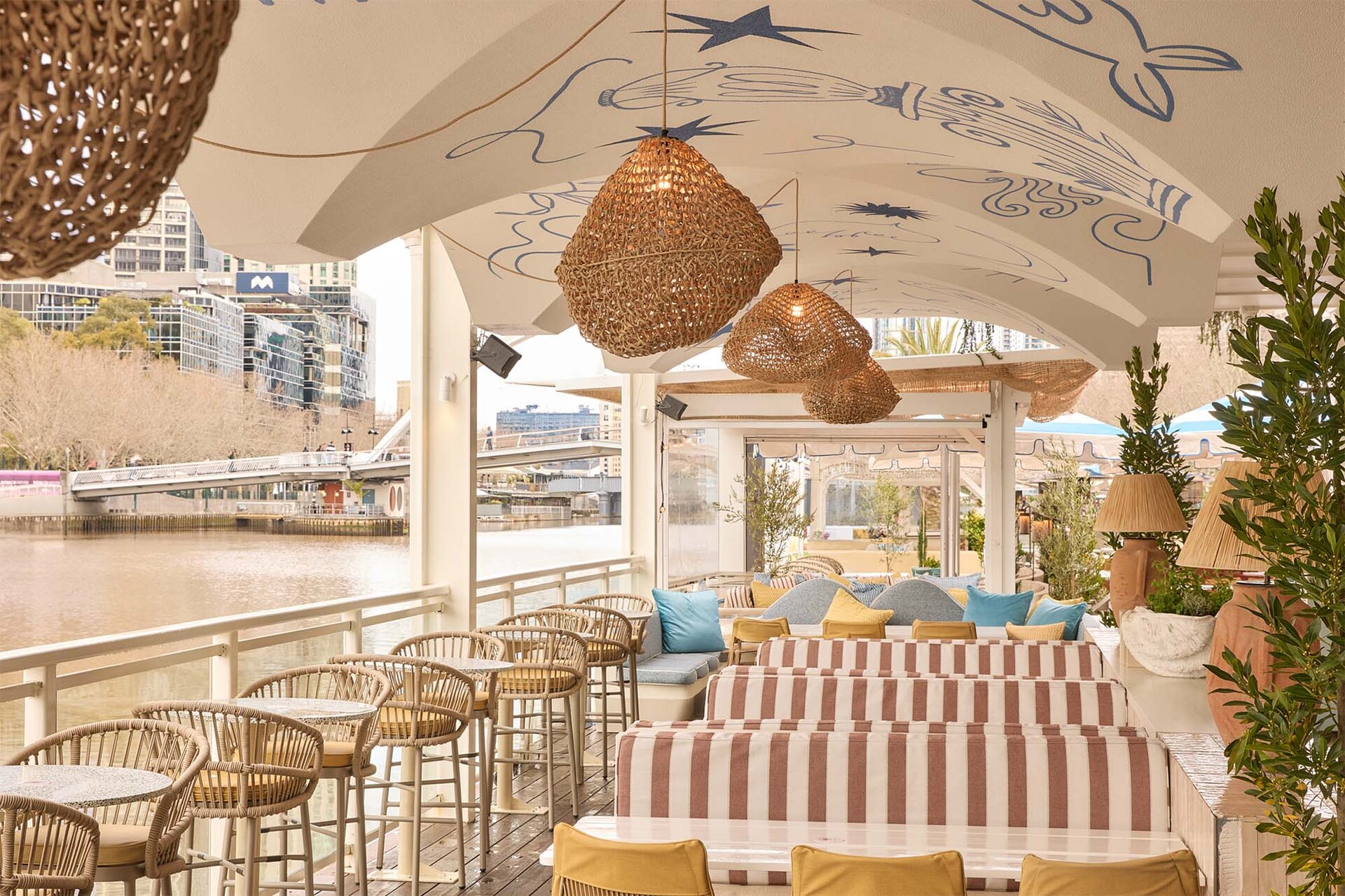 A floating Greek-themed restaurant with striped seats, a painted fresco ceiling and a view of the Yarra River.