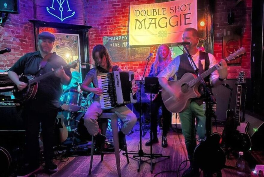 Irish band with accordion and banjo, playing in a brick pub venue.