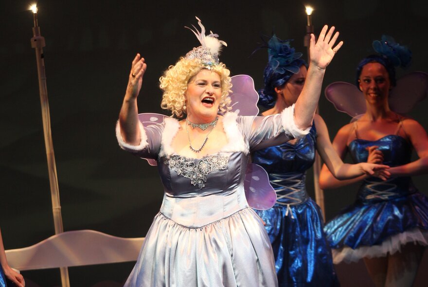 A woman on stage singing in a Gilbert and Sullivan production. 