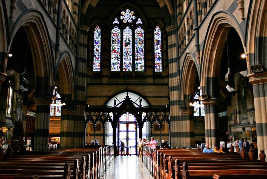 Interior of St Paul's Cathedral with reredos screen, glass-fronted doors and stained-glass windows.