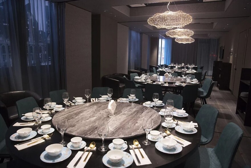 Large round tables with central lazy Susans, cutlery and plates.