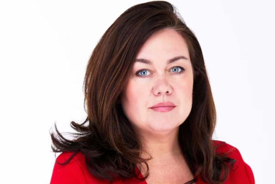 Journalist Samantha Maiden with shoulder-length dark hair, wearing a red top.