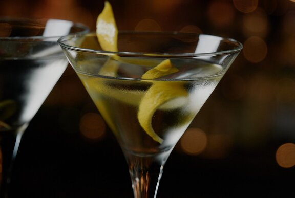 The top half of a martini cocktail in a martini glass with a twist of lemon rind.