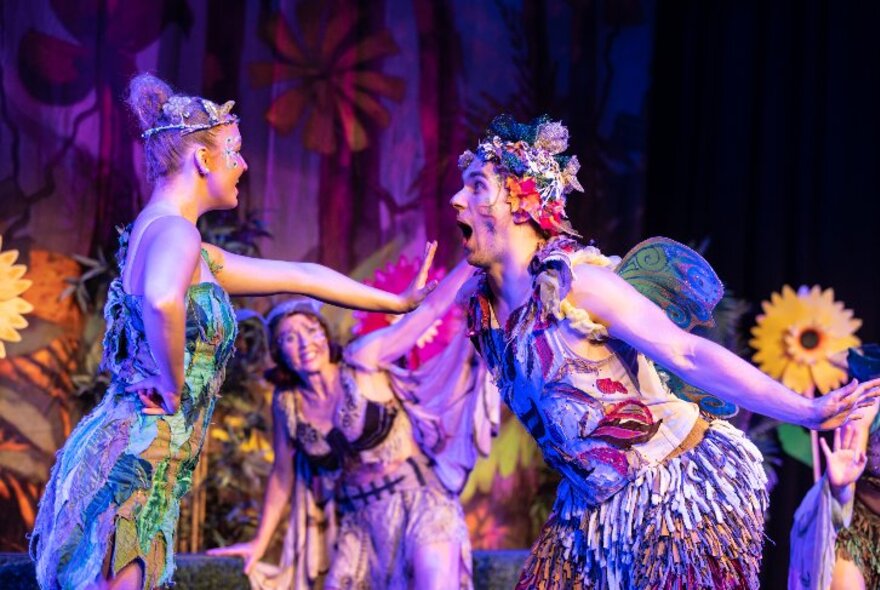 A stage production of Tinkerbell with performers in colourful costumes and exaggerated facial expressions. 