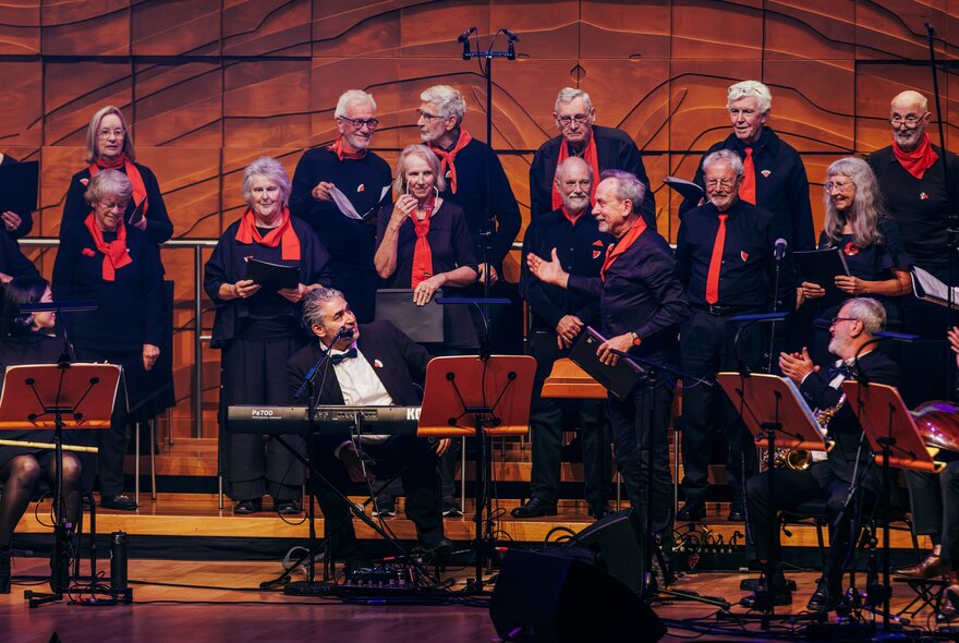 Musicans in formal attire assembled in a concert hall in between performances. 