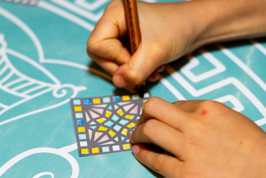 A mosaic workshop at the Melbourne Museum where children create colourful, mosaic-inspired designs on surfaces.
