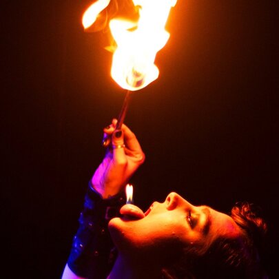 Performer breathing fire with head tilted at an angle.