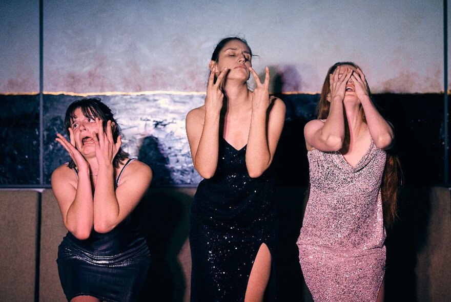 Three comedians posing with thier hands on their faces.