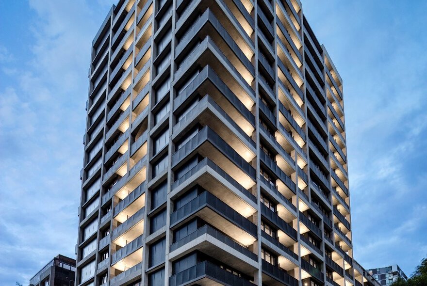 The exterior of Quest NewQuay, a large multi-level building in Docklands, set against a blue sky.