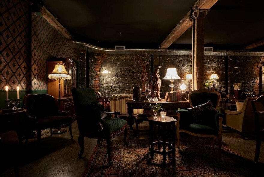 The basement of Mills Place Merchant bar, with exposed bluestone walls, velvet and leather armchairs and a cosy vibe.