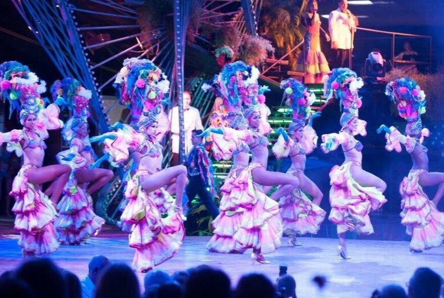 Dancers on stage all dressed alike and performing a latin dance. 
