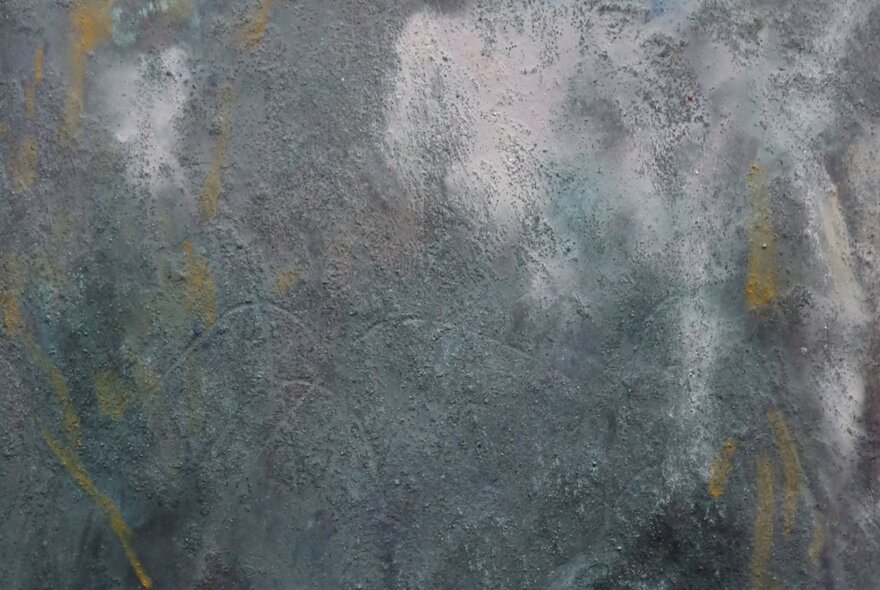 A painted artwork that is a mottled blend of greys and white, with some yellow streaks.