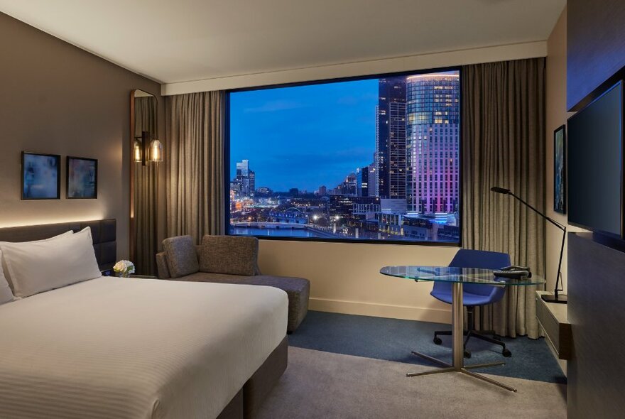 A hotel room with a view of the Melbourne skyline.