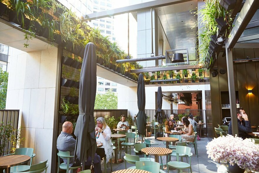 A rooftop bar with umbrellas and plants.