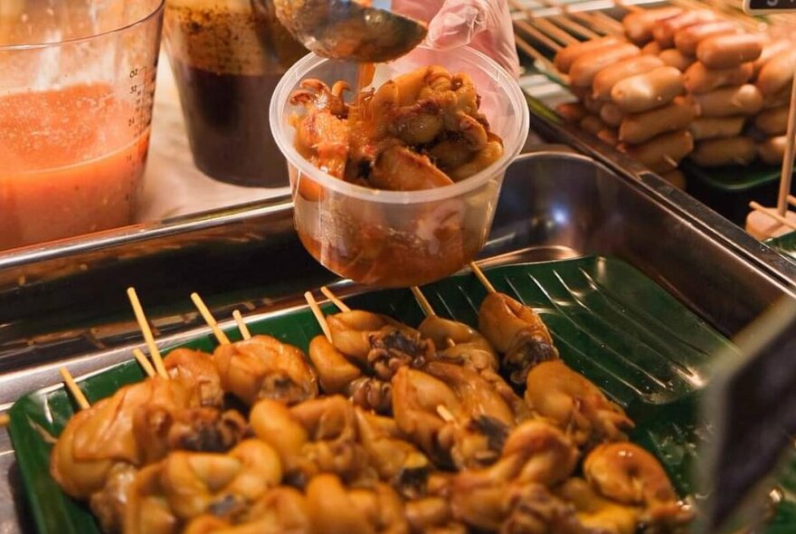 A tray of cooked cooked skewers on display.