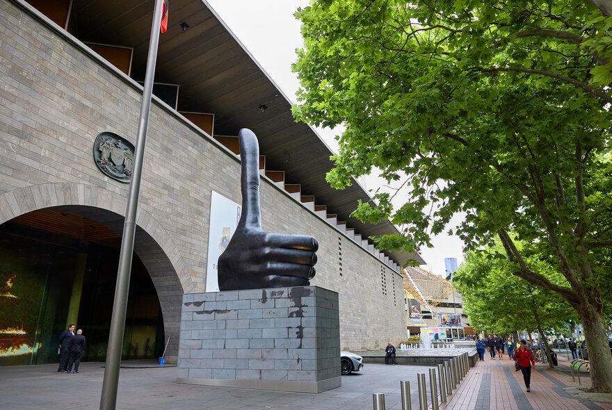 A giant thumb statue outside a gallery.