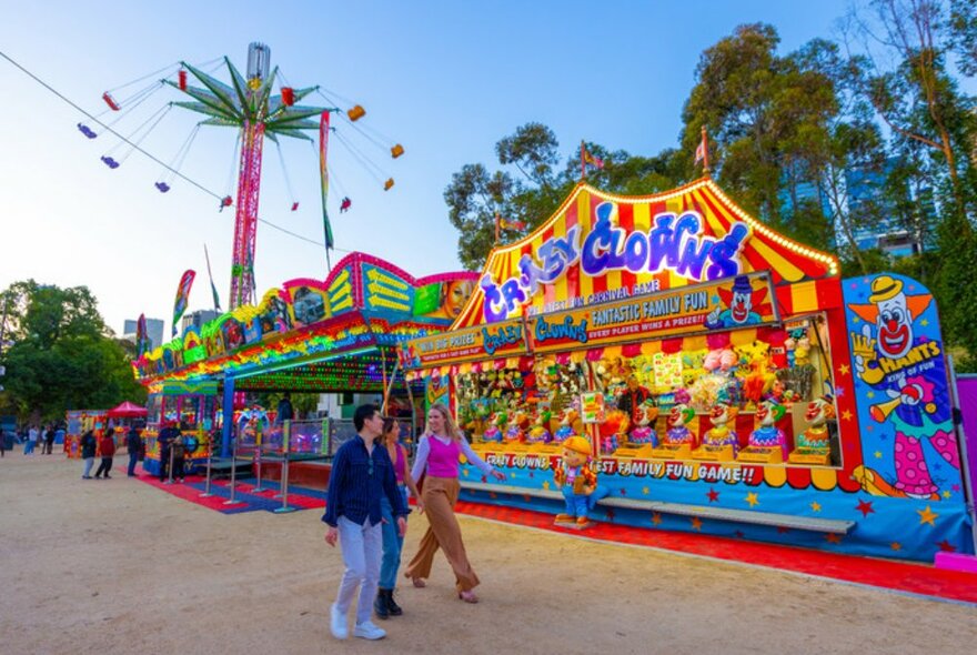 Three friends walking around a colourful carnival. 