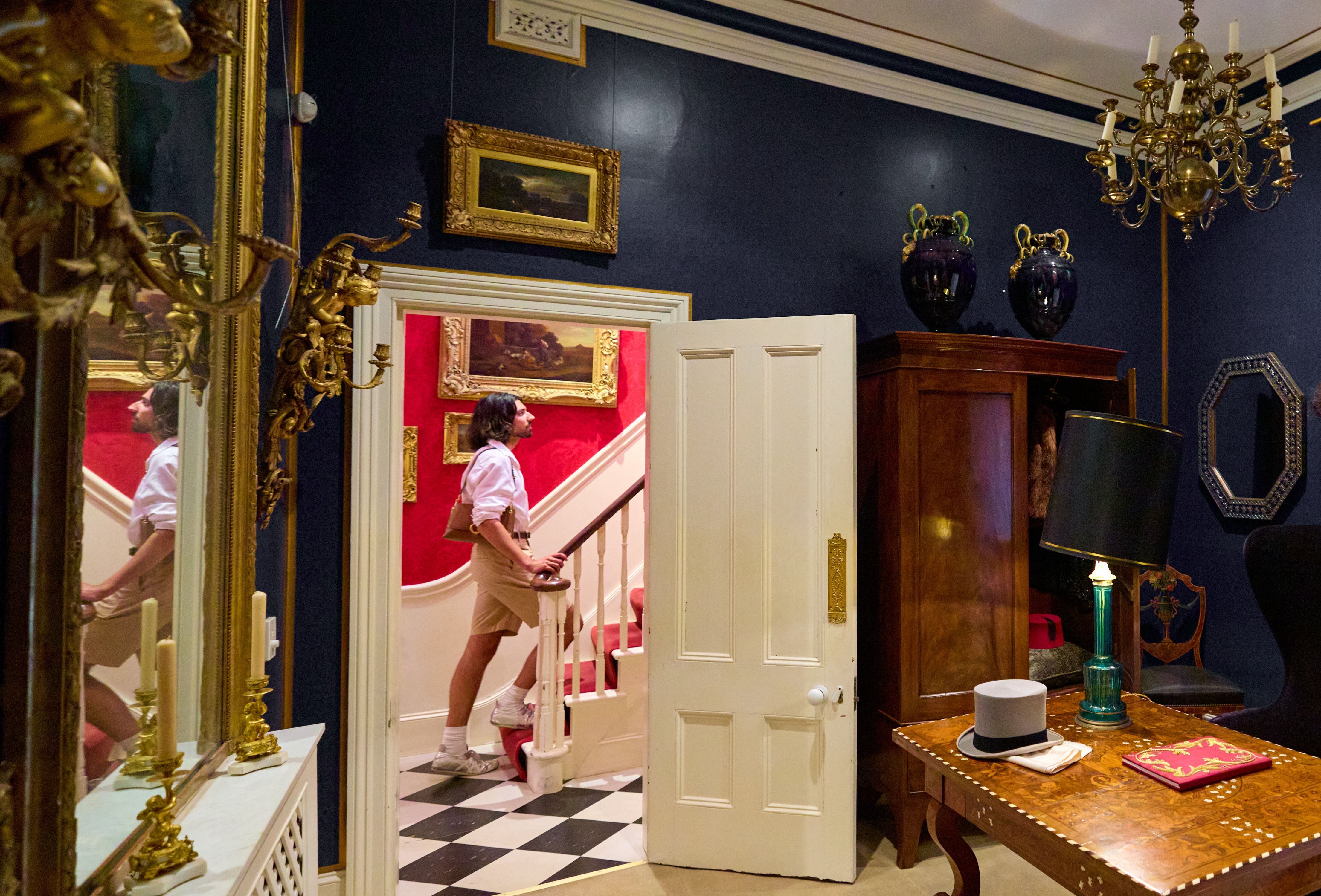 A person walking up the stairs in an ornately decorated home.