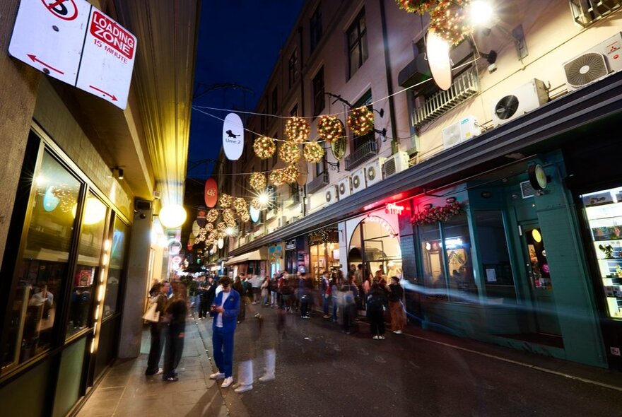 Christmas decorations light up above Degraves Street. 