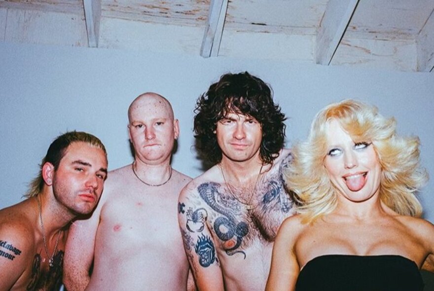 Amyl and the Sniffers musical group, men bare-chested, blonde female with eyes crossed and tongue extended.