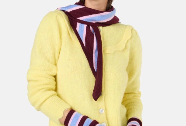A person is wearing a stripe scarf and a yellow cardigan