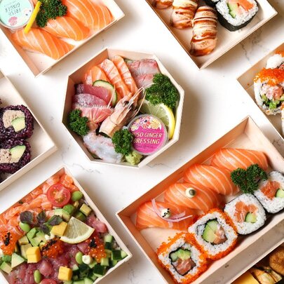 Looking down on a table featuring many different bento and sushi arrangements. 