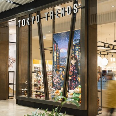 The external facade of a shop called Tokyo Trends, with a large anime poster inside the window.
