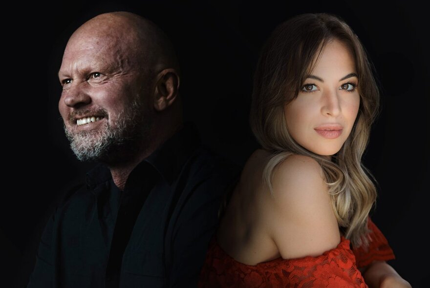 The heads of two opera singers, Teddy Tahu Rhodes and Georgia Wilkinson, back-to-back against a dark background.