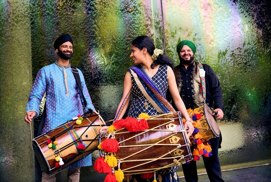 Three traditional Indian drummers in front of the water wall at National Gallery of Victoria.