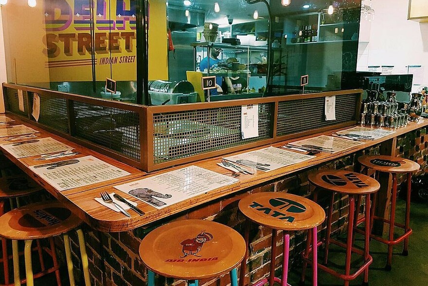 Bar stools around Delhi Streets kitchen.