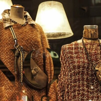Store mannequins displaying layered winter fashion and handbags.