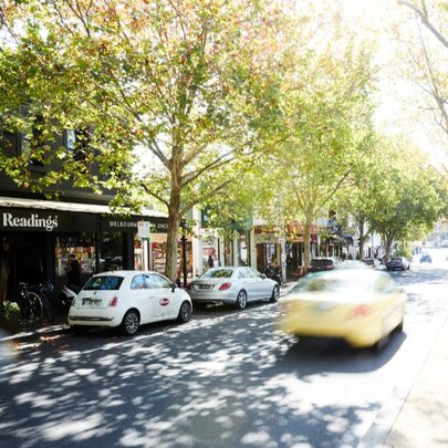 Readings bookstore in leafy Lygon Street with cars whizzing past.