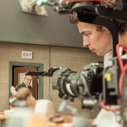 On a film set with a crew member shooting stop motion figures. 