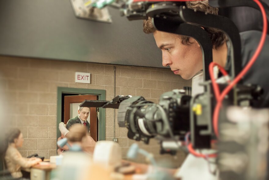On a film set with a crew member shooting stop motion figures. 
